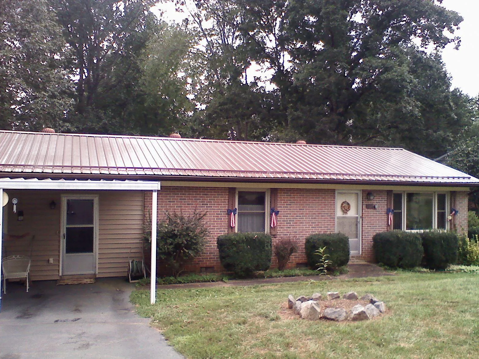 Bronze metal roof and carport on a brick ranch home — Roof Repair work by our crew in White Sulphur Springs